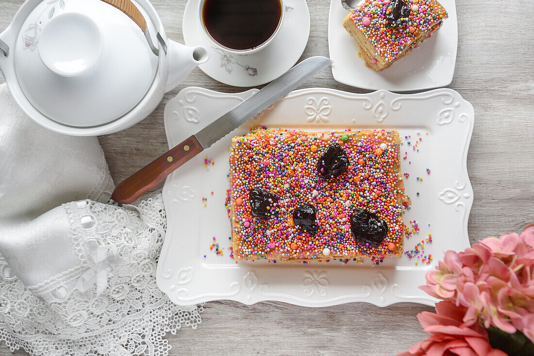 Draufsicht auf köstliches traditionelles Dessert Turron de Dona Pepa mit buntem Dragee auf Teller auf Tisch serviert