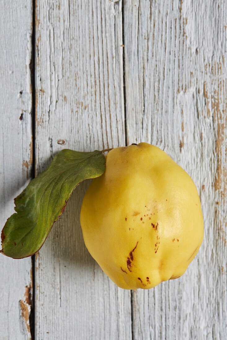 Top view of fresh whole sour yellow lemon on white wooden background