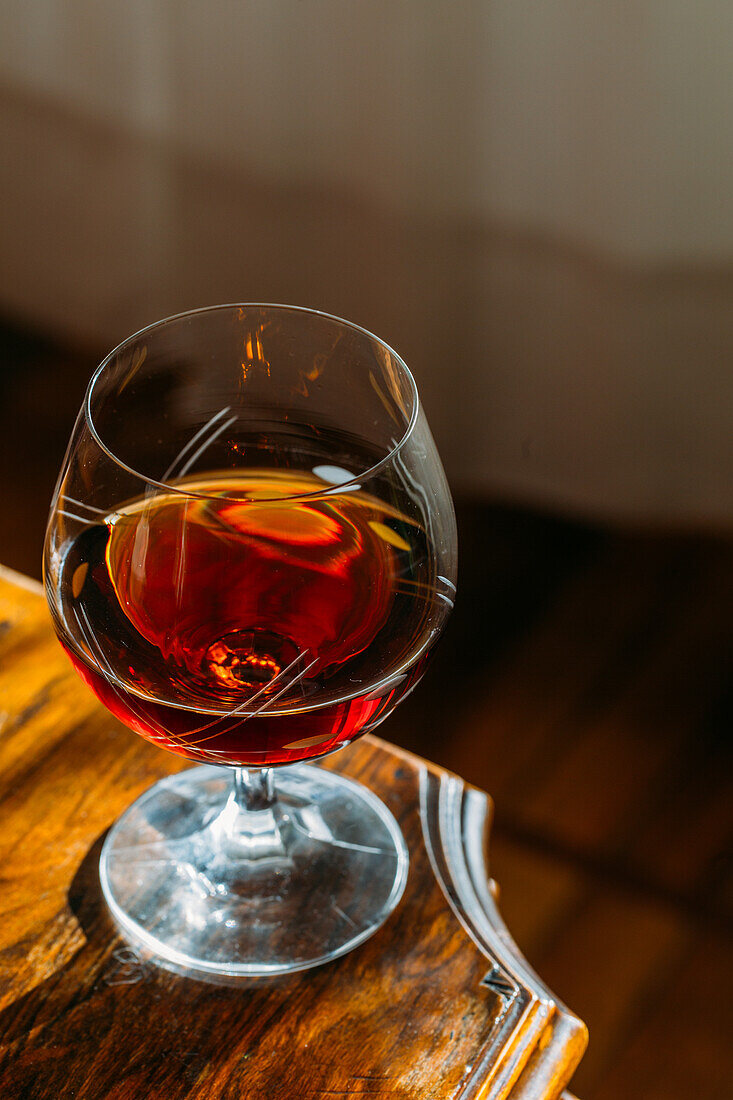 Old fashioned cognac glass on wooden table with natural light