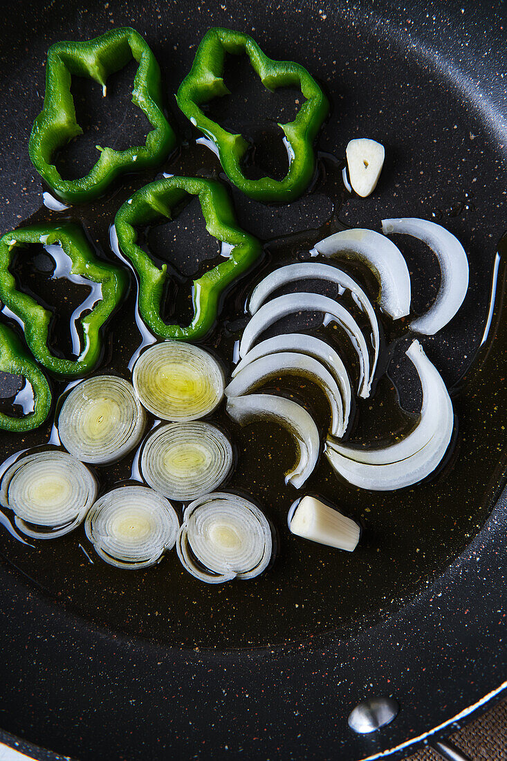 In Scheiben geschnittenes Gemüse auf einer Pfanne mit Olivenöl