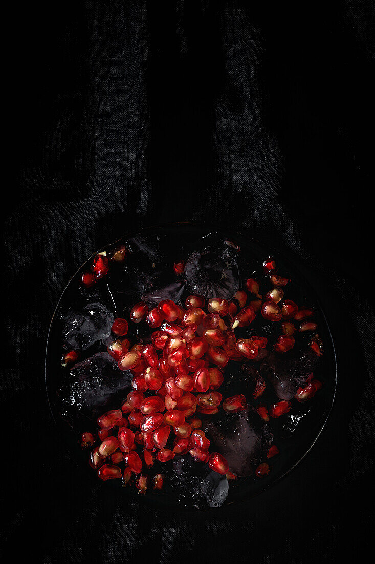 Frischer und roter Granatapfel auf dunklem Hintergrund. Herbstsaison Obst. Top flay; Ansicht von oben