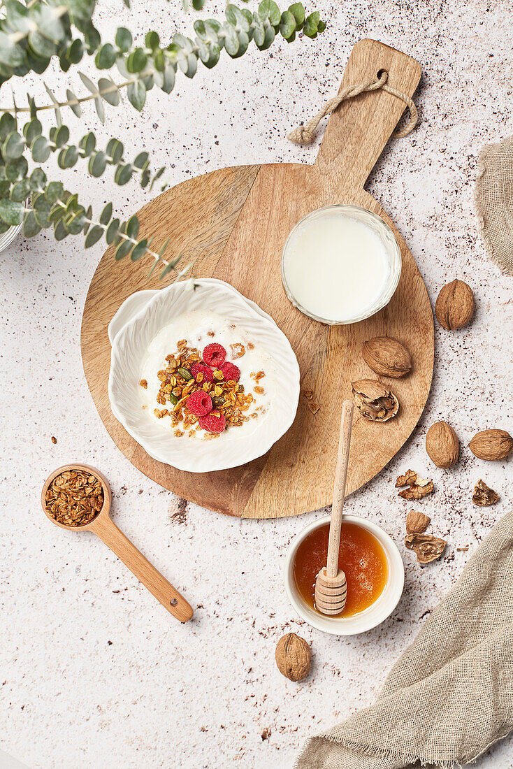 Draufsicht auf ein leckeres Müsli mit süßem Honig und frischen Milchprodukten, das zum Frühstück serviert wird