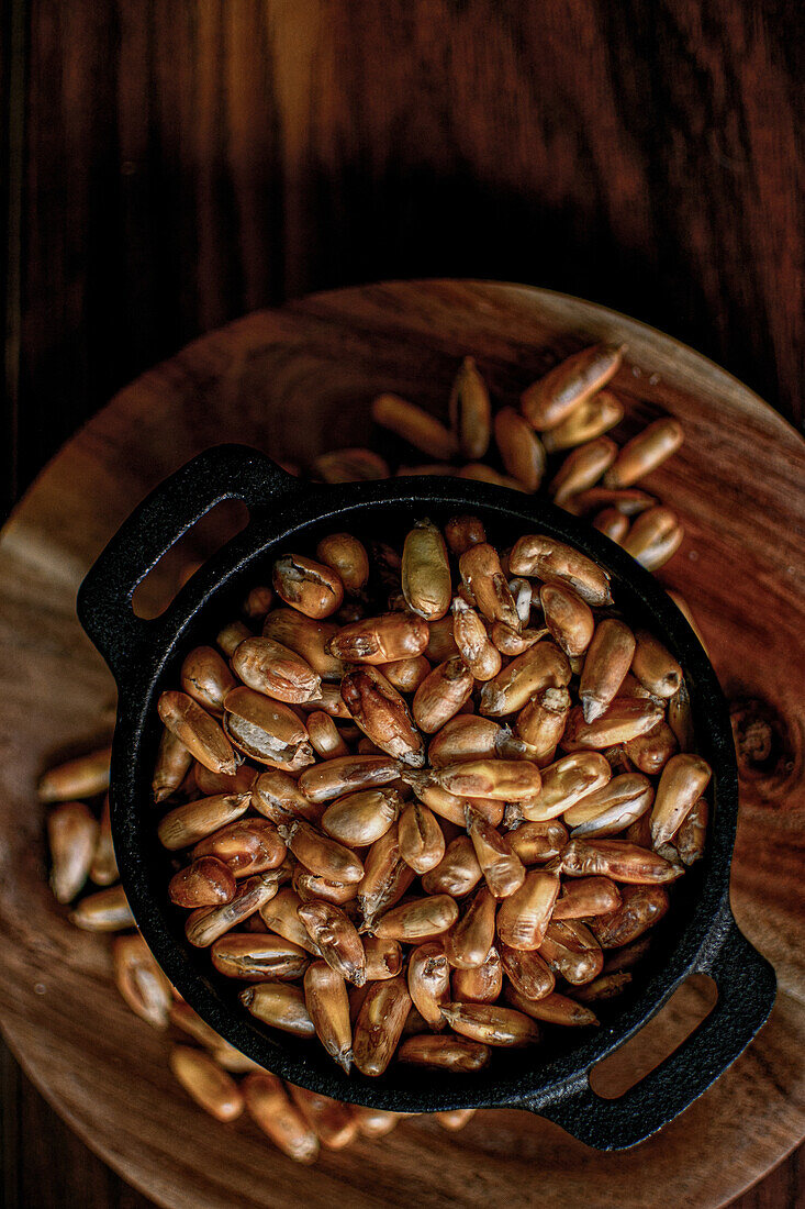 Top view of pile of cereal grain in bowl placed on wooden table in kitchen