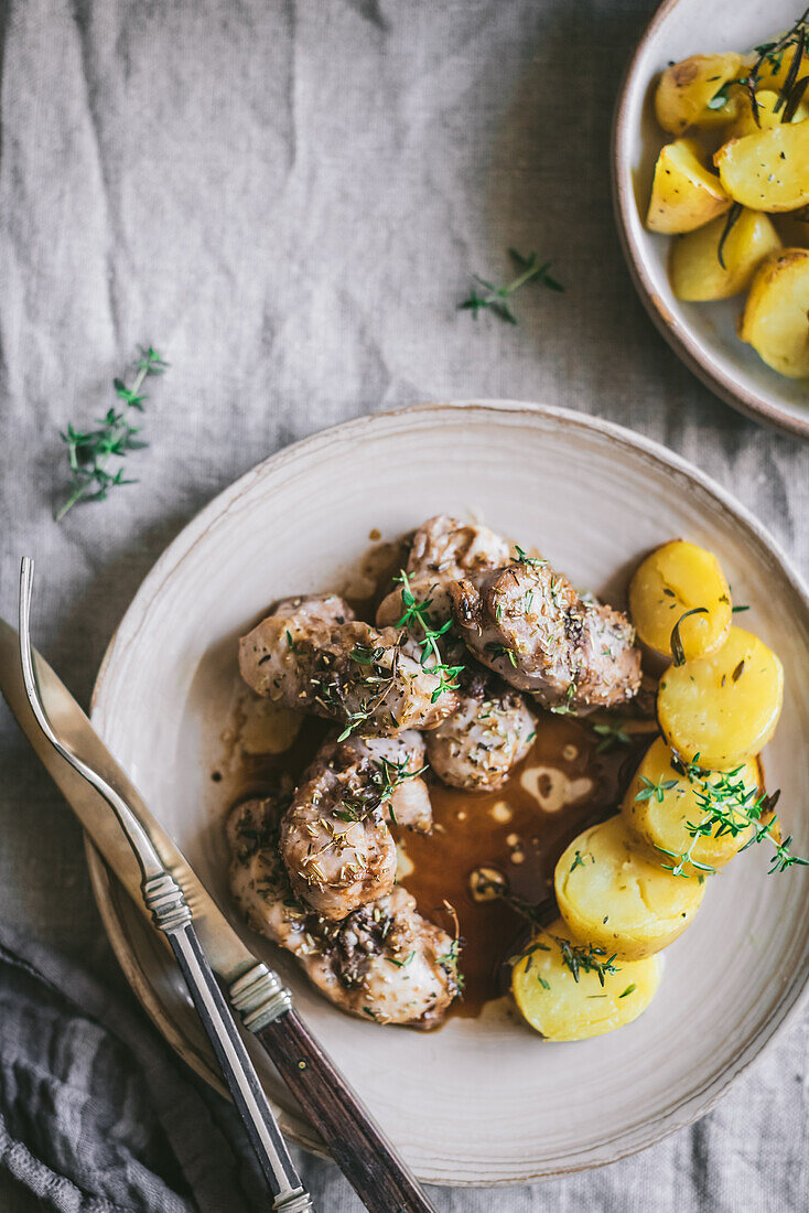 Von oben von appetitlichem Eintopf mit Kartoffeln und Kaninchenfleisch in einem Teller auf einem rustikalen Tisch serviert