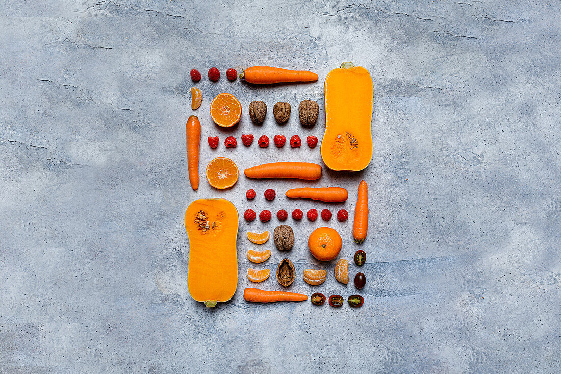 Still life of assorted autumn veggies, pumpkins, apples, persimmons, tangerines and hazelnuts from above