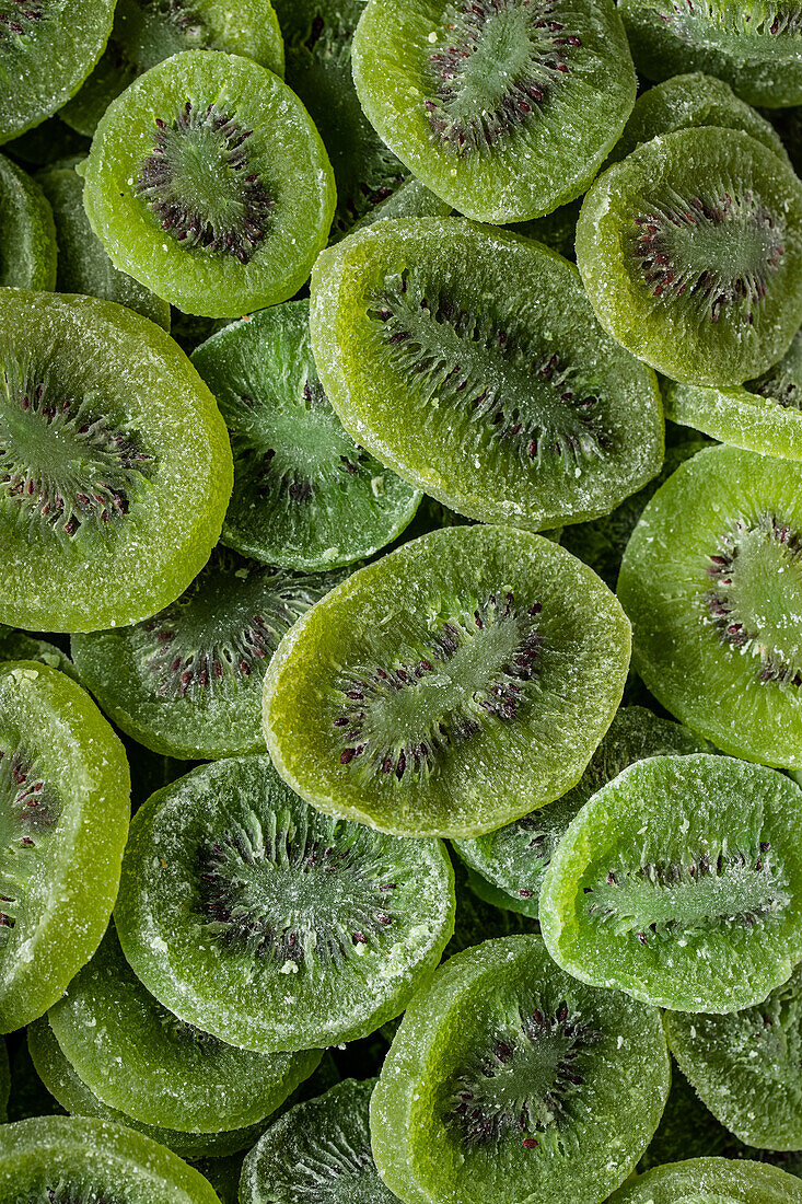 Vollbildansicht von oben auf einen Stapel geschnittener süßer, grüner, trockener Kiwi mit Zucker auf der Oberfläche