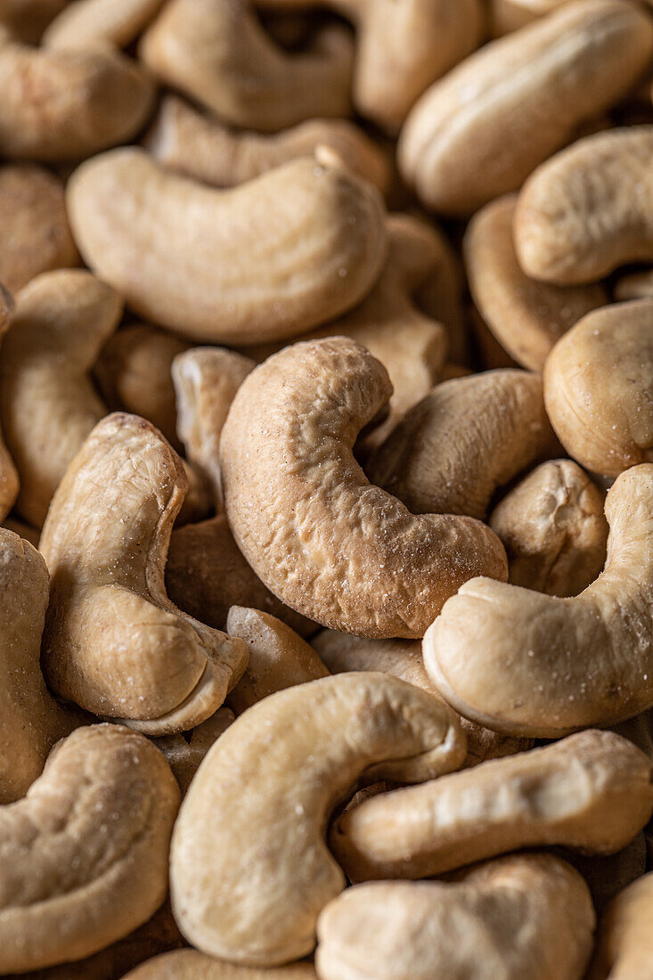 Full frame top view of huge amount of raw tasty cashews placed on smooth surface