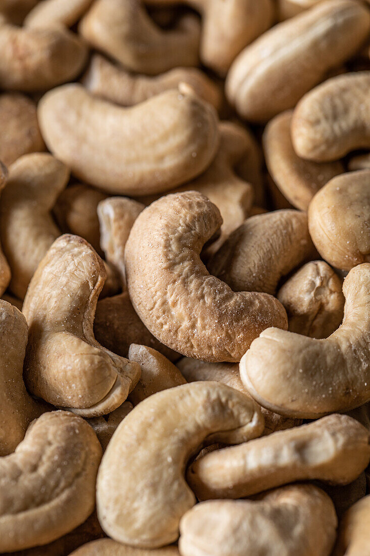 Vollbildansicht von oben einer großen Menge roher, schmackhafter Cashews auf glatter Oberfläche