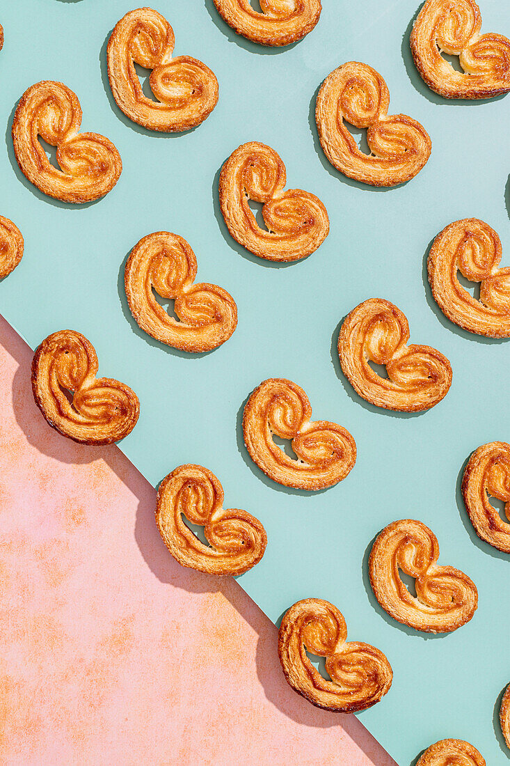 Top view of delicious baked elephant ear cookies placed in lines on colorful surface