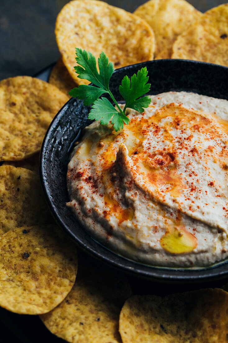 Delicious hummus with paprika, olive oil and some bread to dip