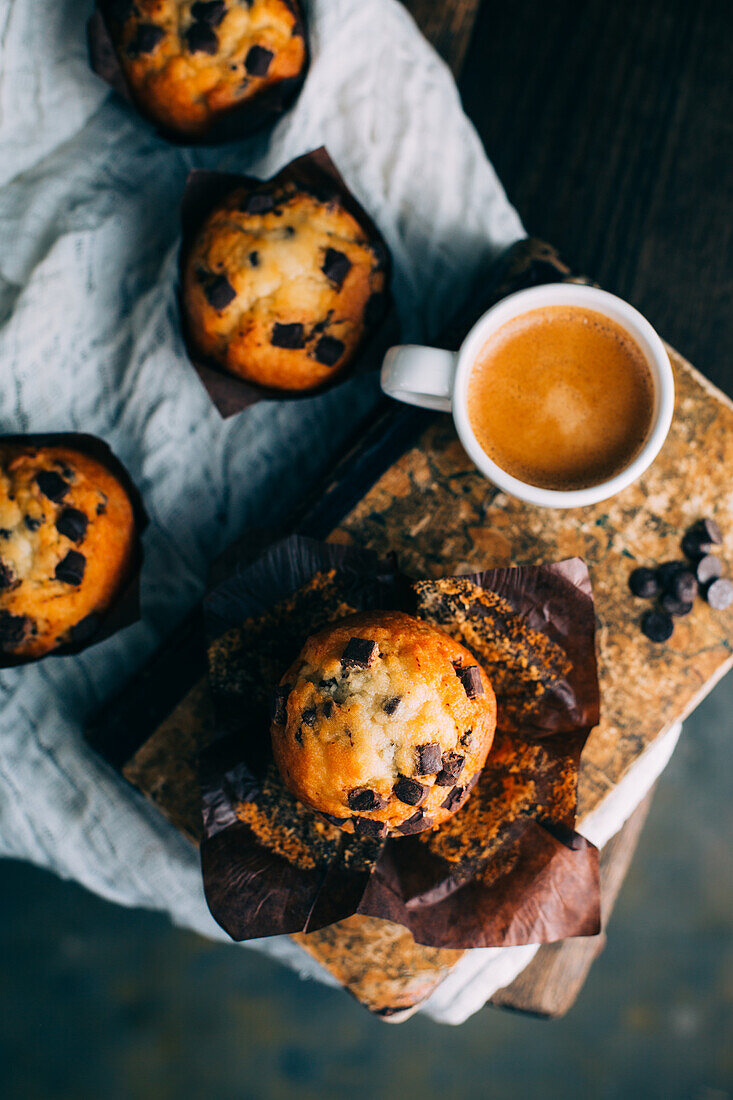 Chocolate muffins and coffee cup on dark background