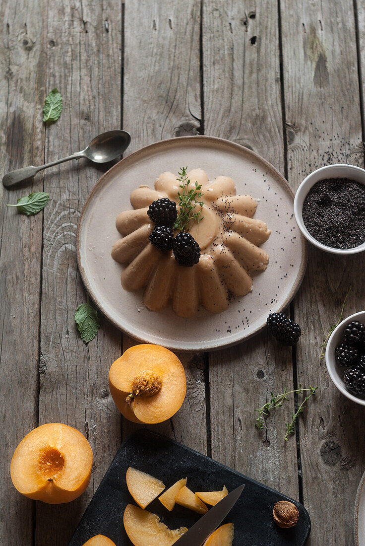 Closeup of served vegan panna cotta with peach and shiny sweet blackberry