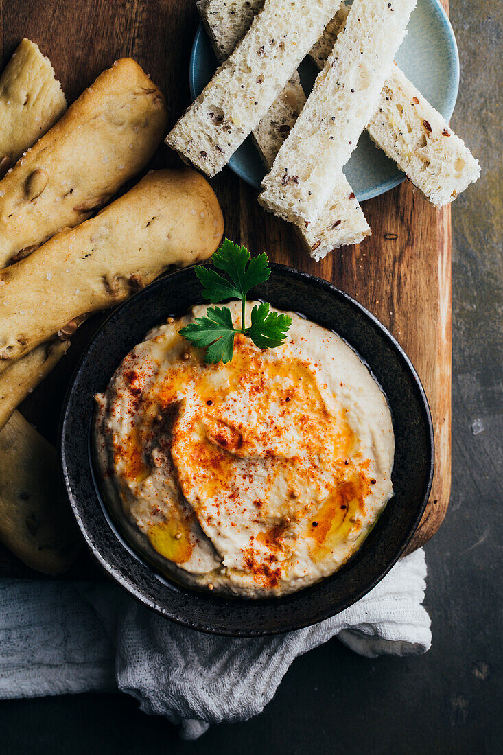 Delicious hummus with paprika, olive oil and some bread to dip