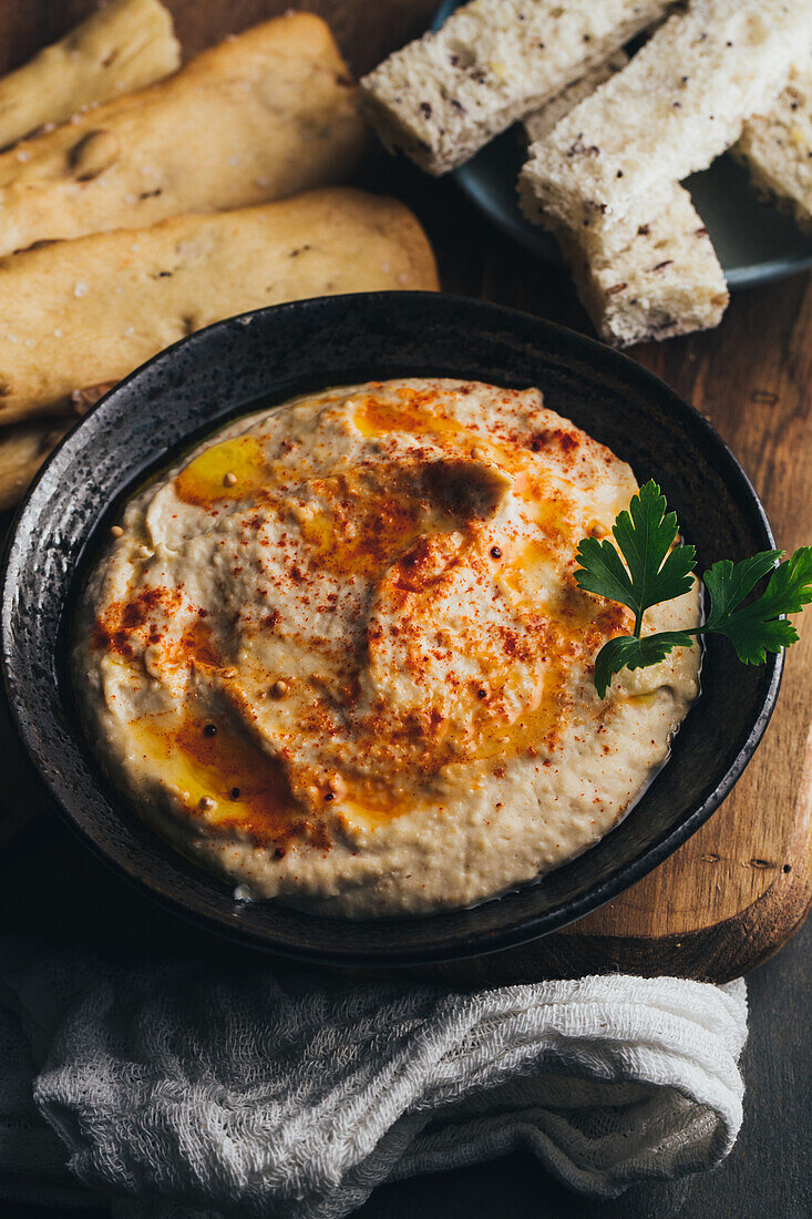 Delicious hummus with paprika, olive oil and some bread to dip