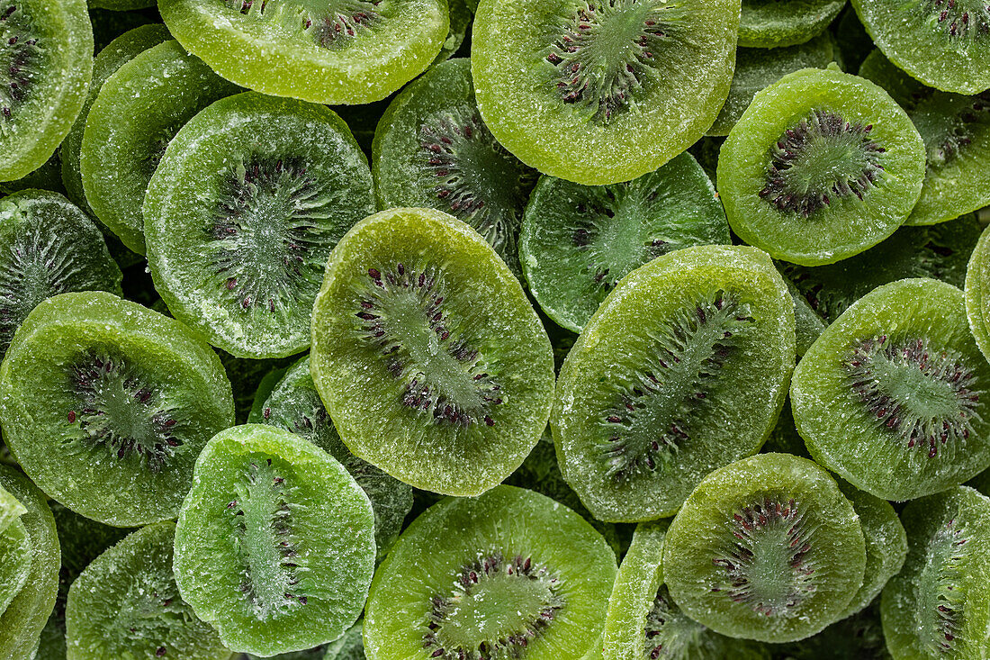 Vollbildansicht von oben auf einen Stapel geschnittener süßer, grüner, trockener Kiwi mit Zucker auf der Oberfläche