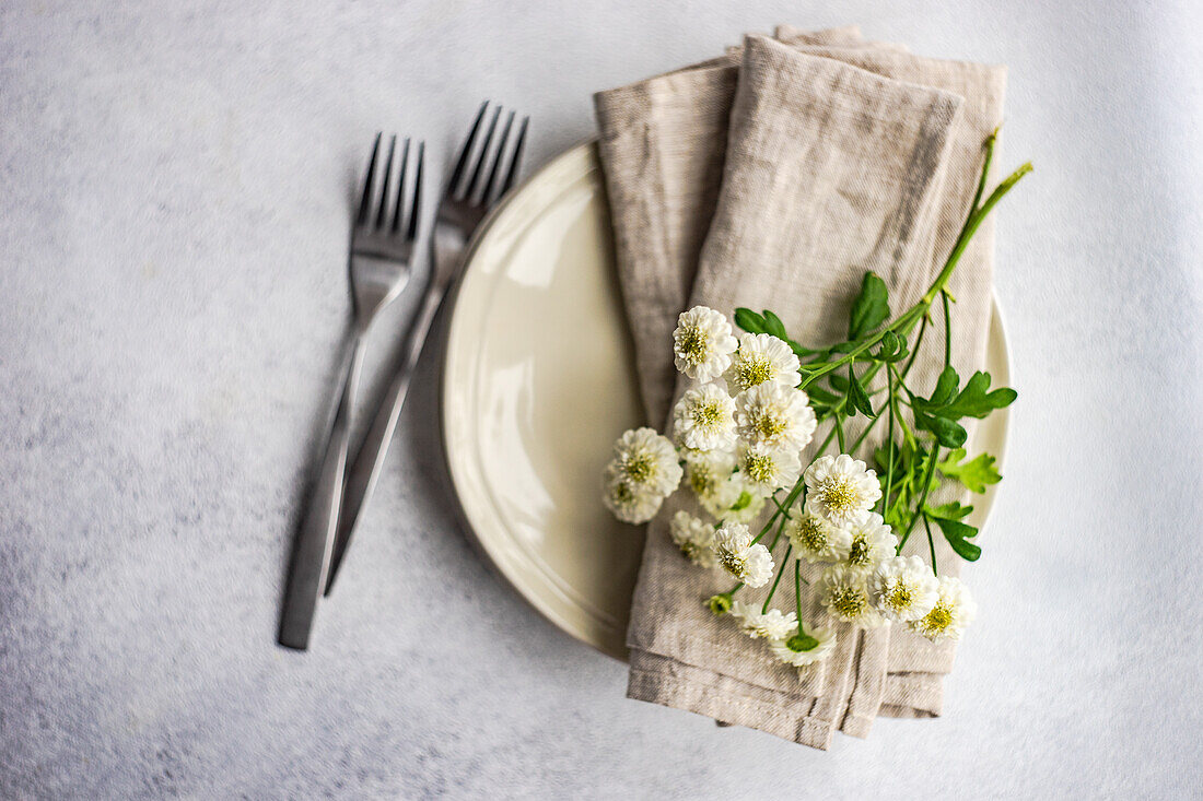 From above mini aster flowers in the plate set decor on concrete table