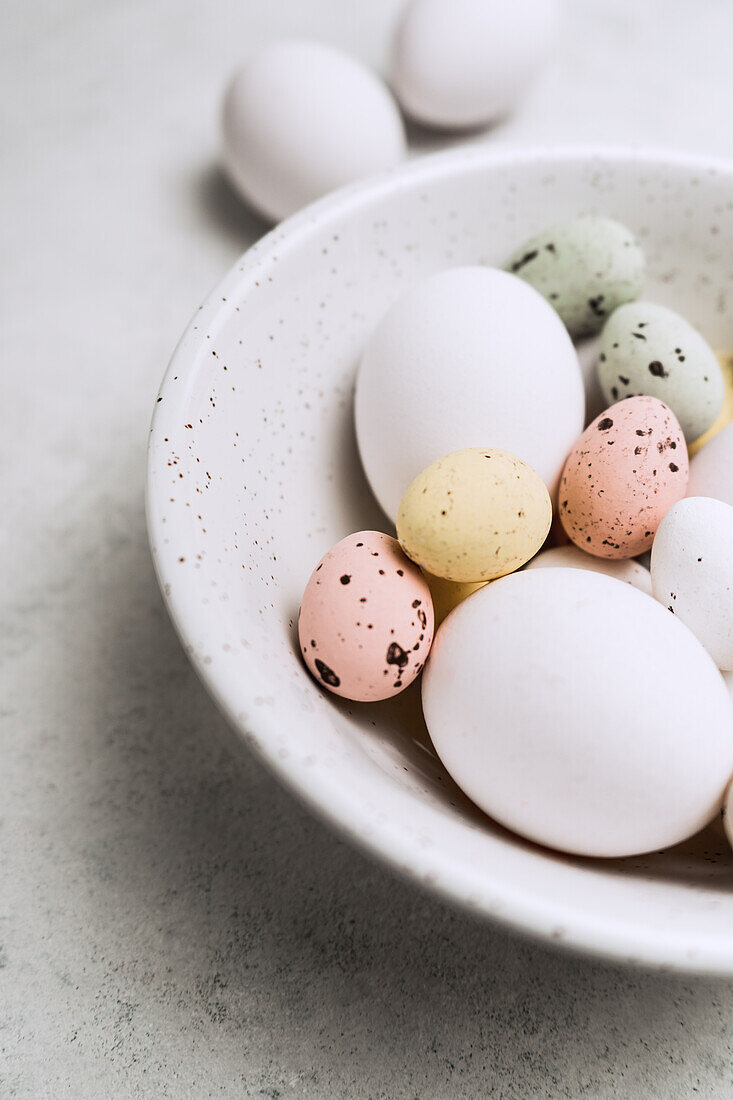 From above still life of beautiful painted Easter eggs over white table background