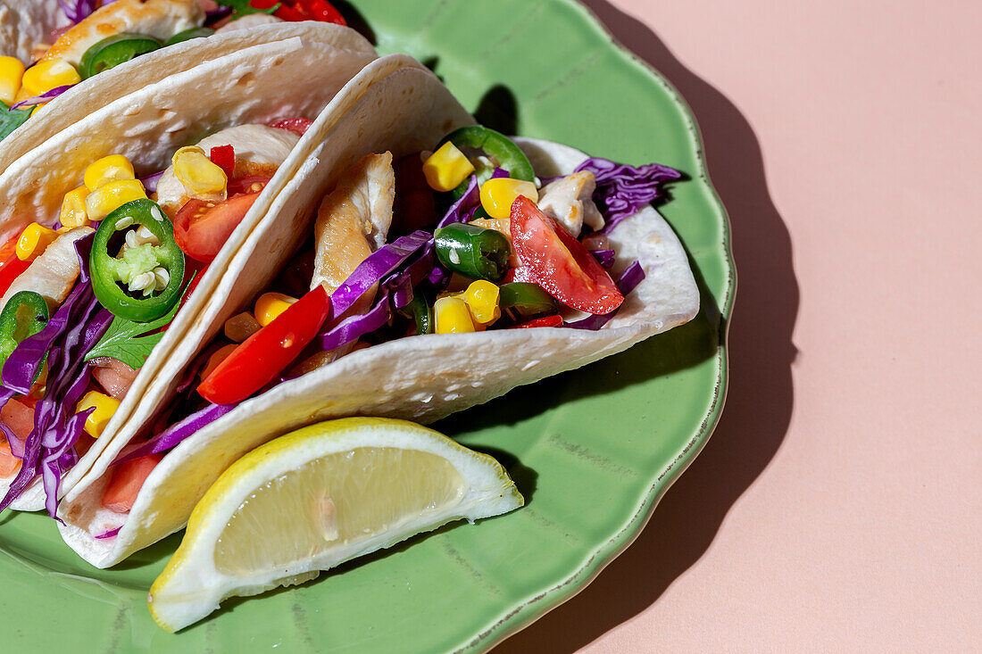 Hausgemachte mexikanische Tacos mit frischem Gemüse und Huhn mit starkem Licht auf rosa Hintergrund. Gesundes Essen. Typisch mexikanisch