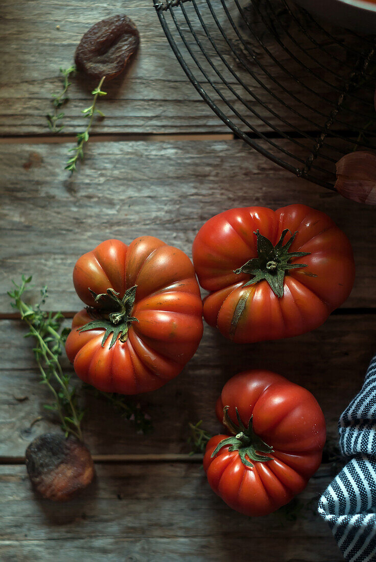 Von oben reife rote Tomaten mit gestreifter Serviette auf Holztisch