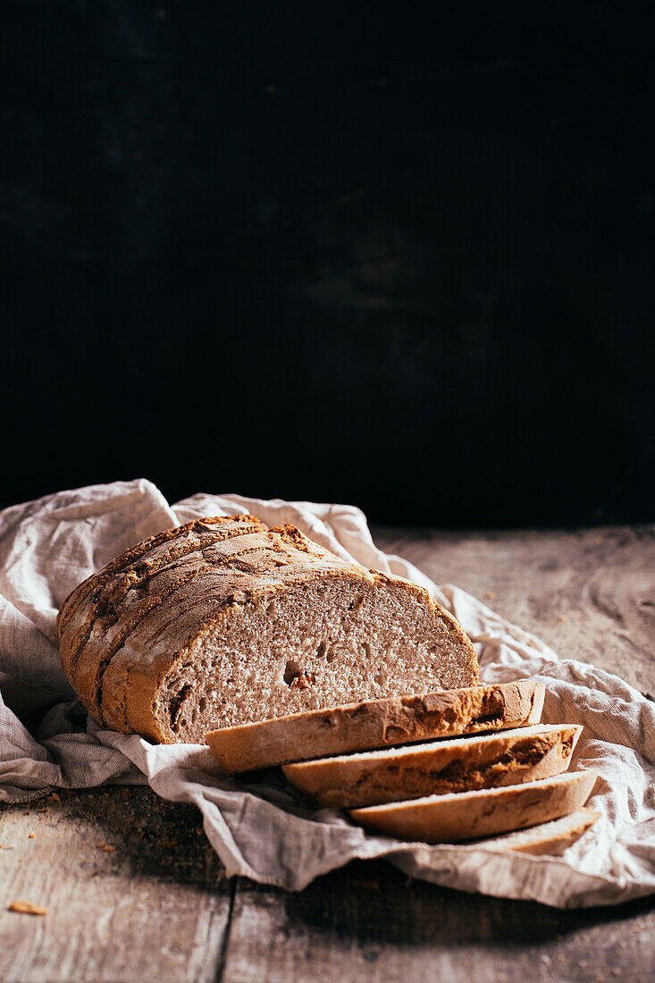 From above of slices of freshly baked wholegrain bread scattered on aged shabby wooden table in kitchen