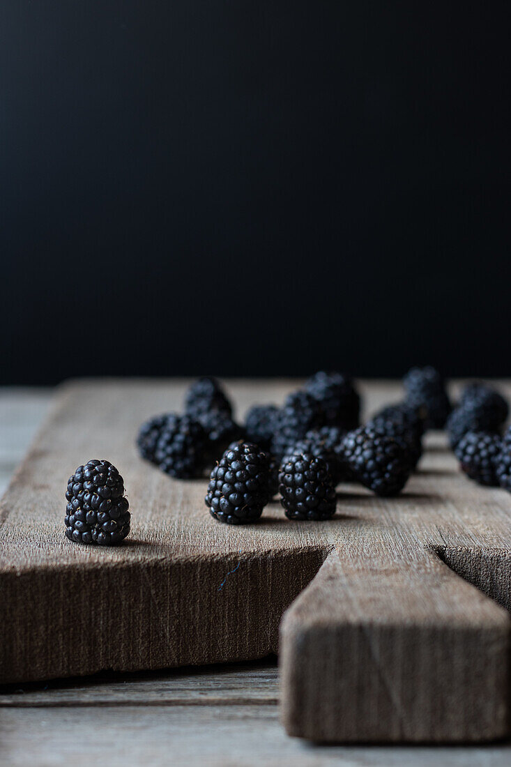 Fresh ripe blueberries laid on wooden chopping board on black background