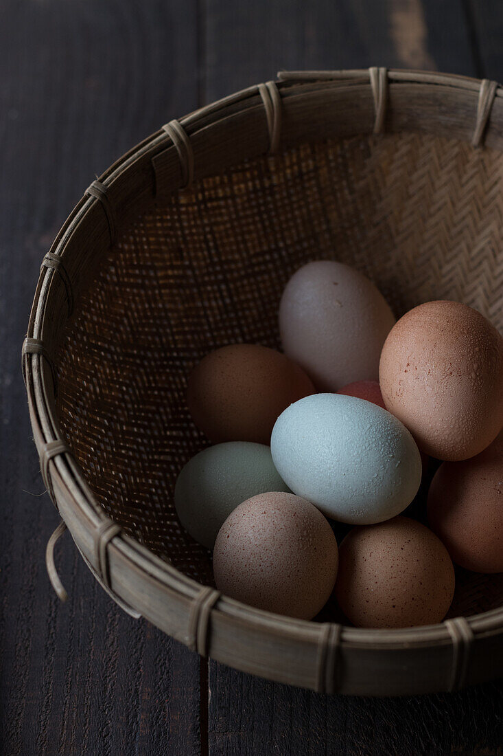 From above shot of wicker basket filled with brown and white eggs on table