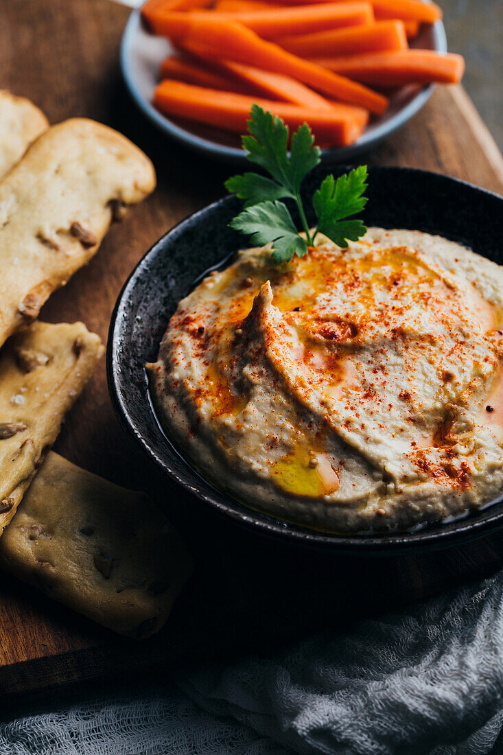 Leckerer Hummus mit Paprika, Olivenöl und etwas Brot zum Dippen