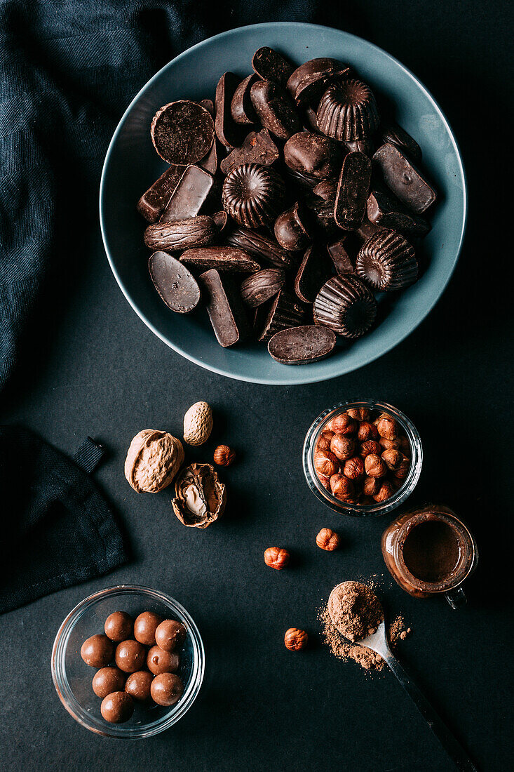 From above various handmade chocolates with nuts arranged placed on black table