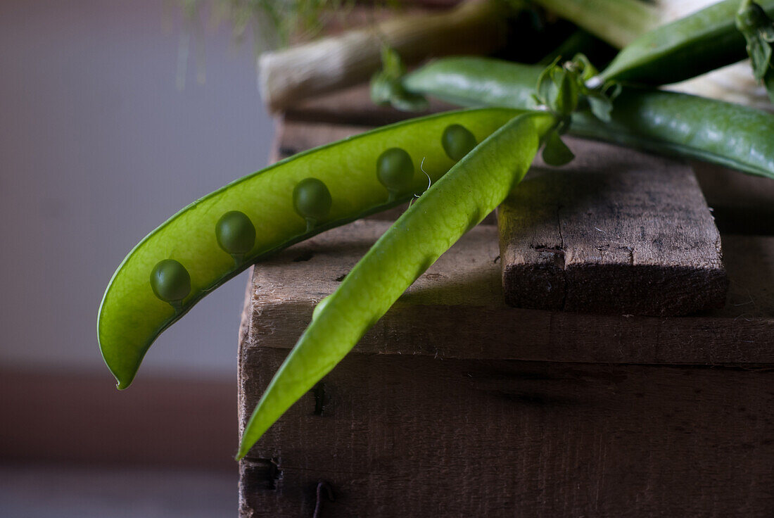 Composition of ripe and delicious green mint leaves with basil and pea pod with fennel on wood