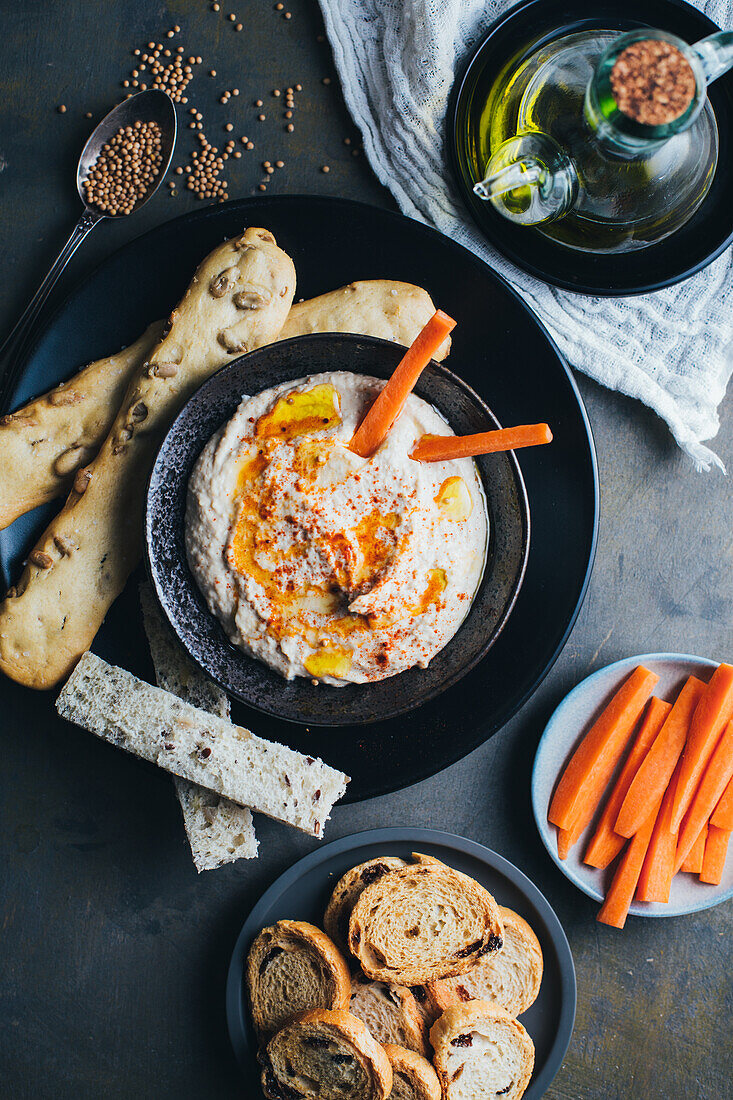 Leckerer Hummus mit Paprika, Olivenöl und etwas Brot zum Dippen