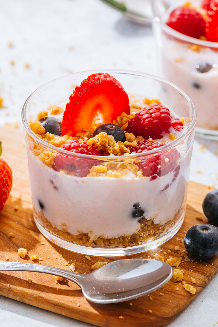 Close up of delicious homemade yogurt with strawberries, berries and cereals on white background