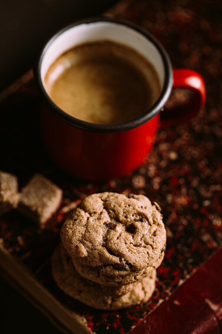 Homemade chocolate chips cookies on a old vintage book served with coffee on a mug