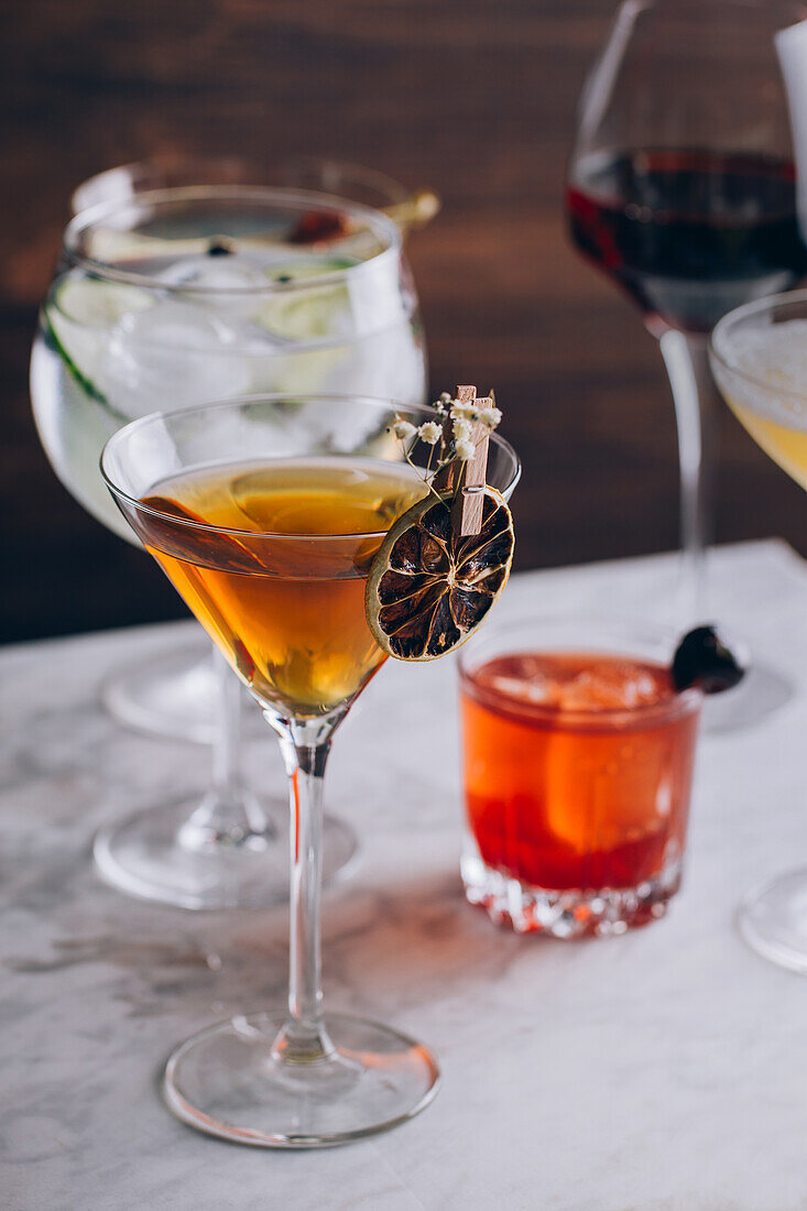 Set of various contemporary classic alcohol cocktails in different glasses placed on table