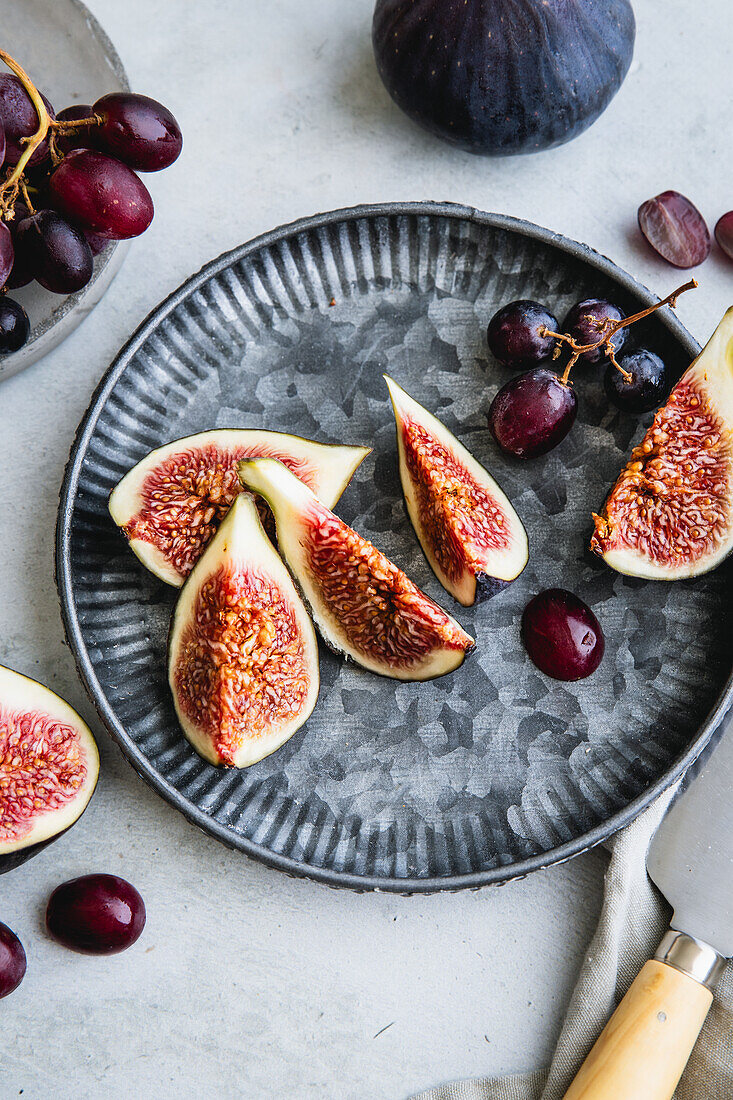 Autumnal fruit on a metal plate - figs and blue grapes