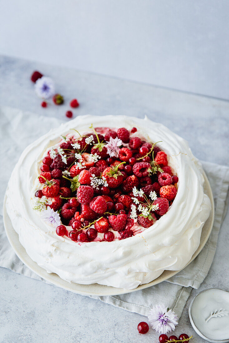 Pavlova with red summer berries and cream