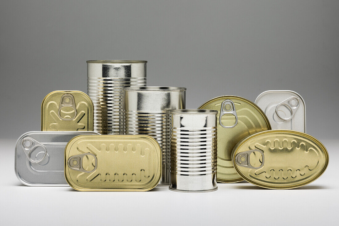 Stacked unopened metal cans on grey background