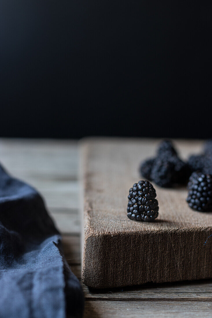 Fresh ripe blueberries laid on wooden chopping board on black background