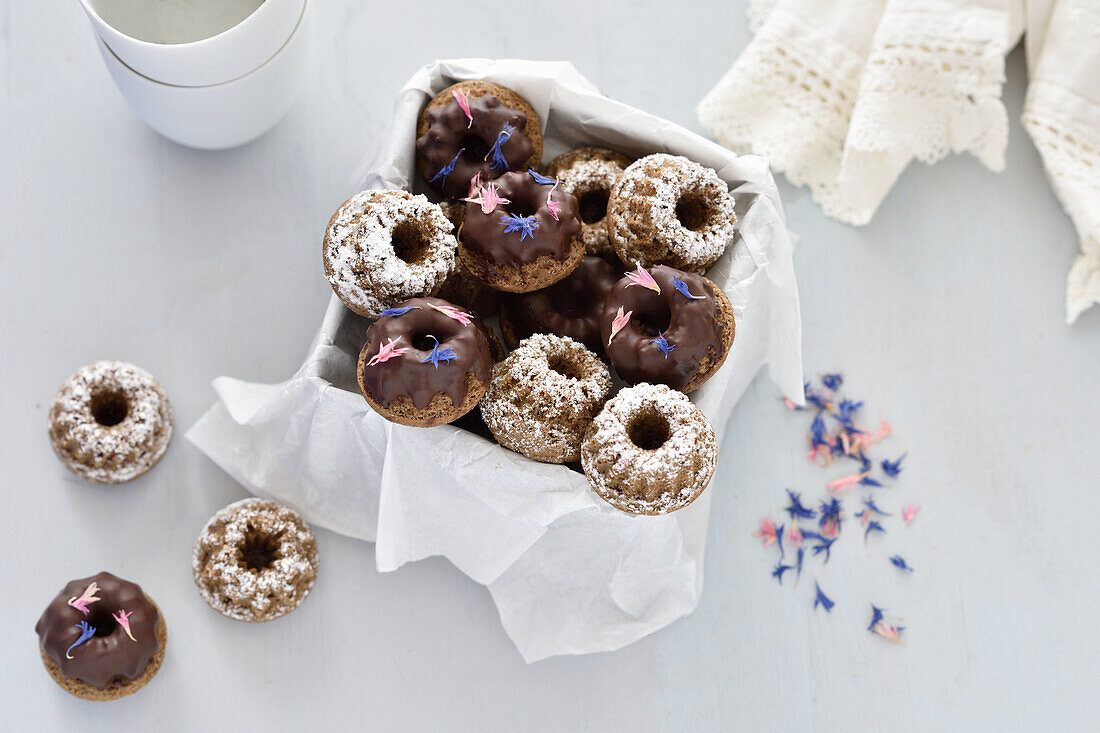 Vegan mini almond bundt cakes with chocolate icing and icing sugar