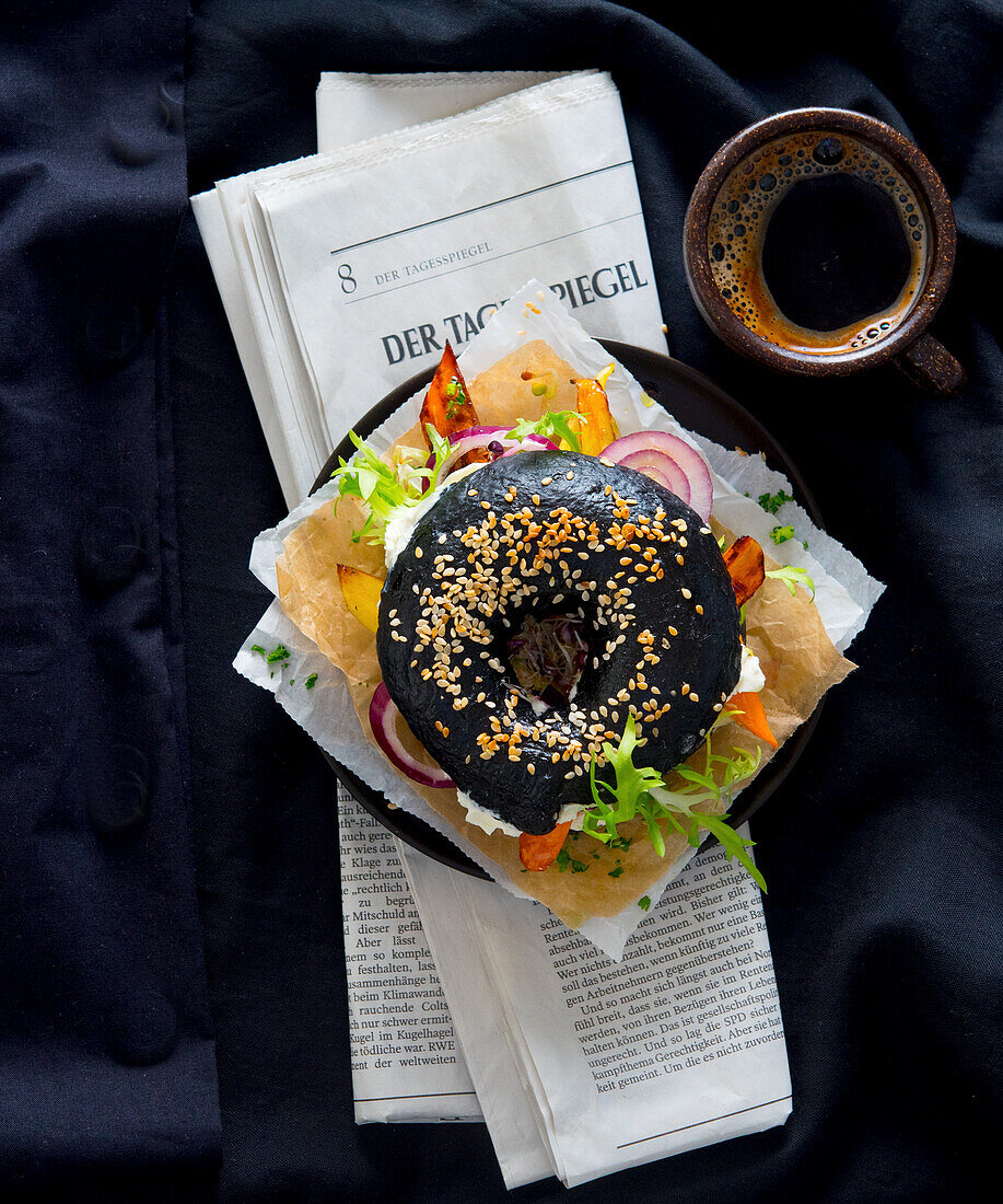 Schwarzer Sesam-Bagel mit Mozzarella und geröstetem Gemüse