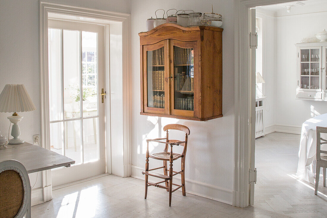 Raum mit antikem Holzschrank an der Wand, Blick ins Esszimmer