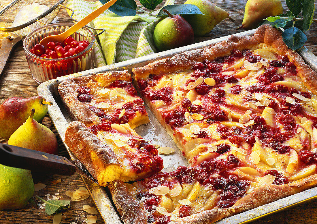 Pear and cranberry cake, on baking tray, pieces cut