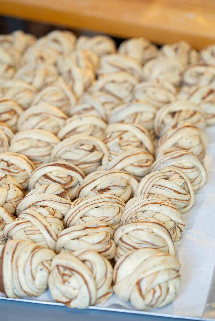 Frische Zimtknoten auf einem Backblech vor dem Backen