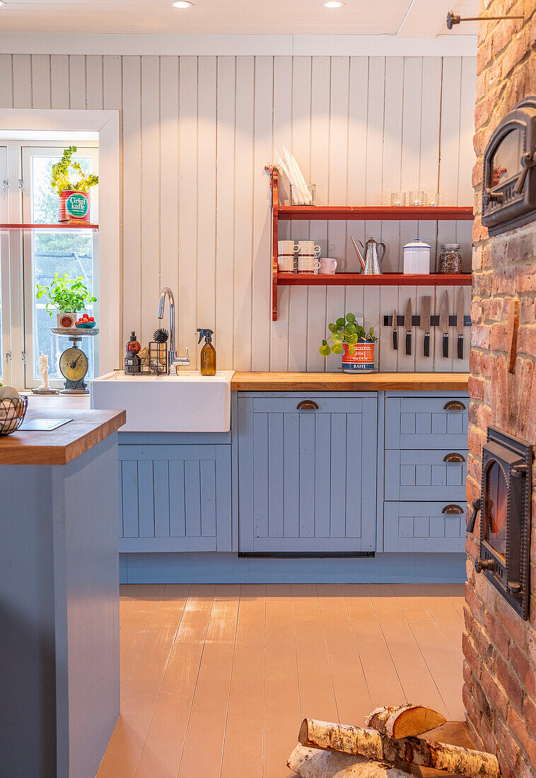 Country kitchen in blue, firewood and stove