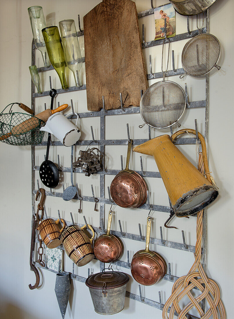 Kitchen wall bracket with copper pots, sieves and various kitchen utensils