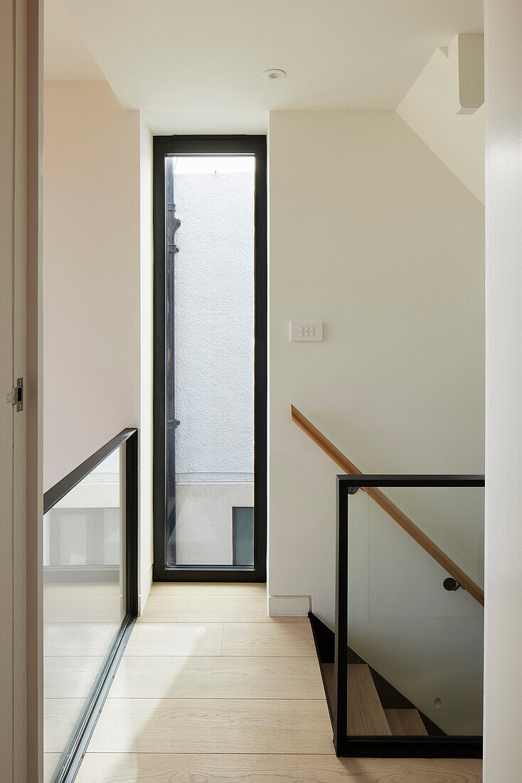 Hallway with wooden banister and elongated window