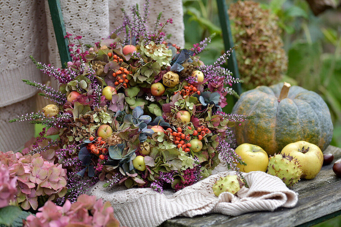 Bunter Herbstkranz mit Hortensien (Hydrangea), Heidekraut, Zieräpfeln und Vogelbeeren