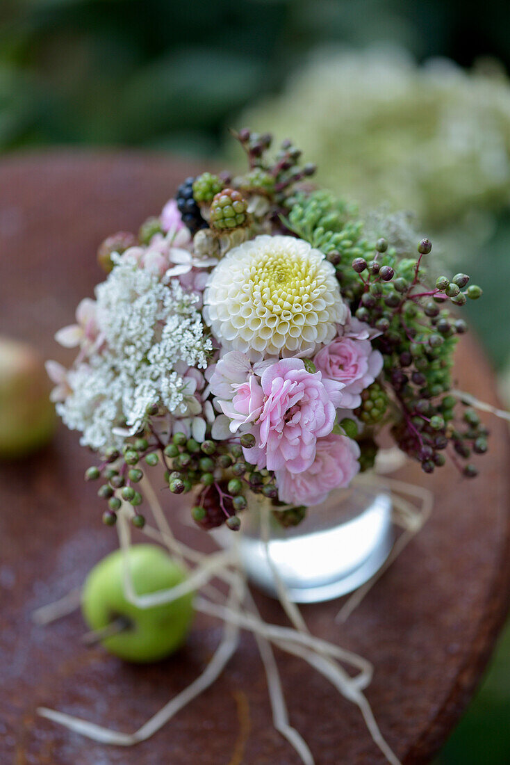 Late summer bouquet with roses, dahlias (Dahlia) and berries on garden table