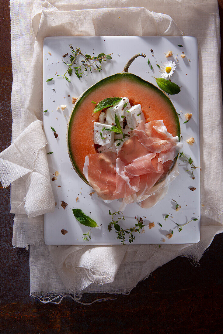 Melon with Parma ham, feta and herbs