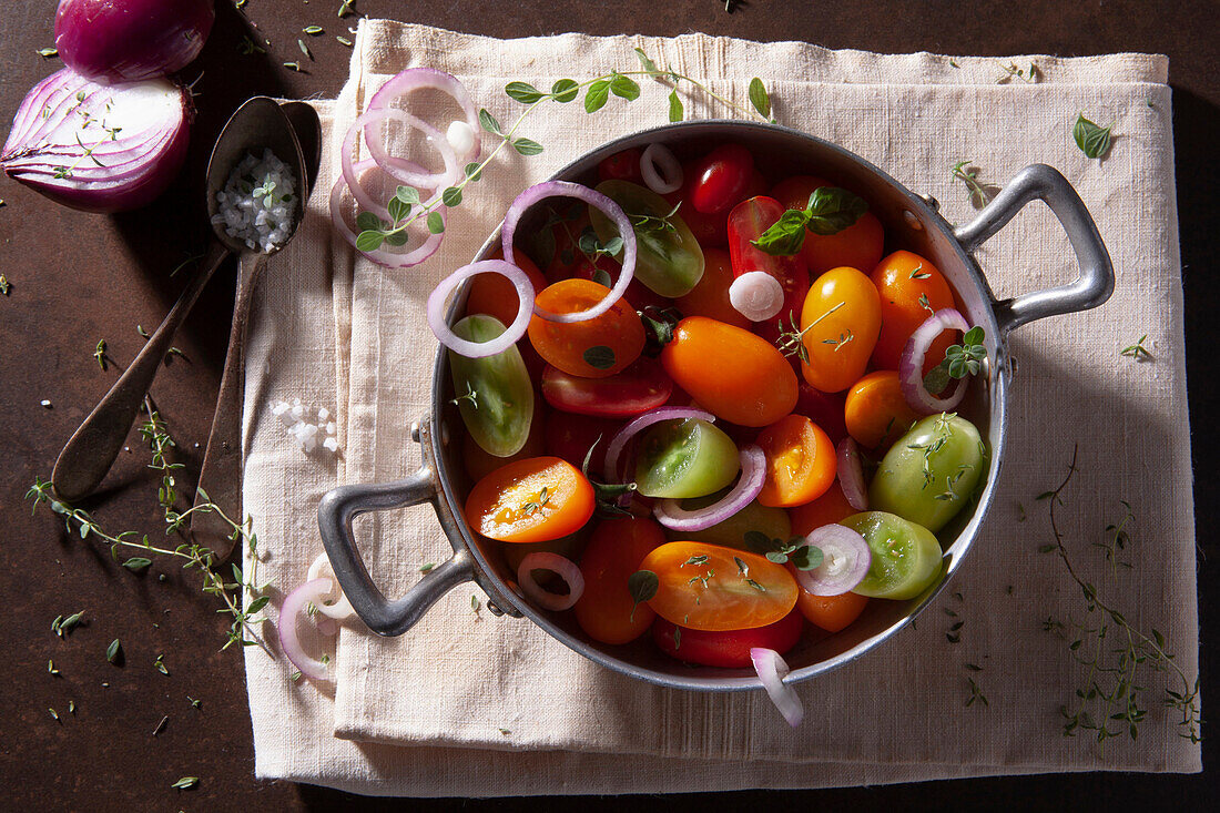 Colourful cherry tomatoes with onion rings and herbs
