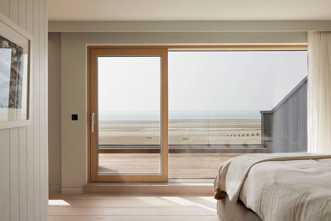 Bedroom with view of the beach through large sliding glass door